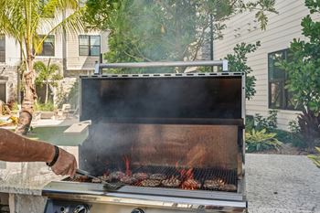 A man is grilling meat on a barbecue